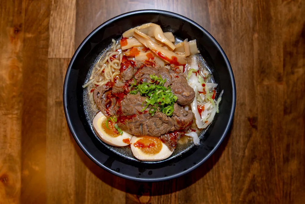 Ramen topped with sliced beef, chili oil, scallions and a soft-boiled egg